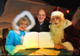 Weihnachtsmann und Märchentante tragen sich nach 25 Dienstjahren ins goldene Gästebuch der Hansestadt Rostock ein